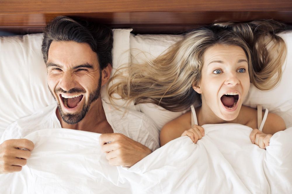 large_couple_laughing_in_bed.jpg
